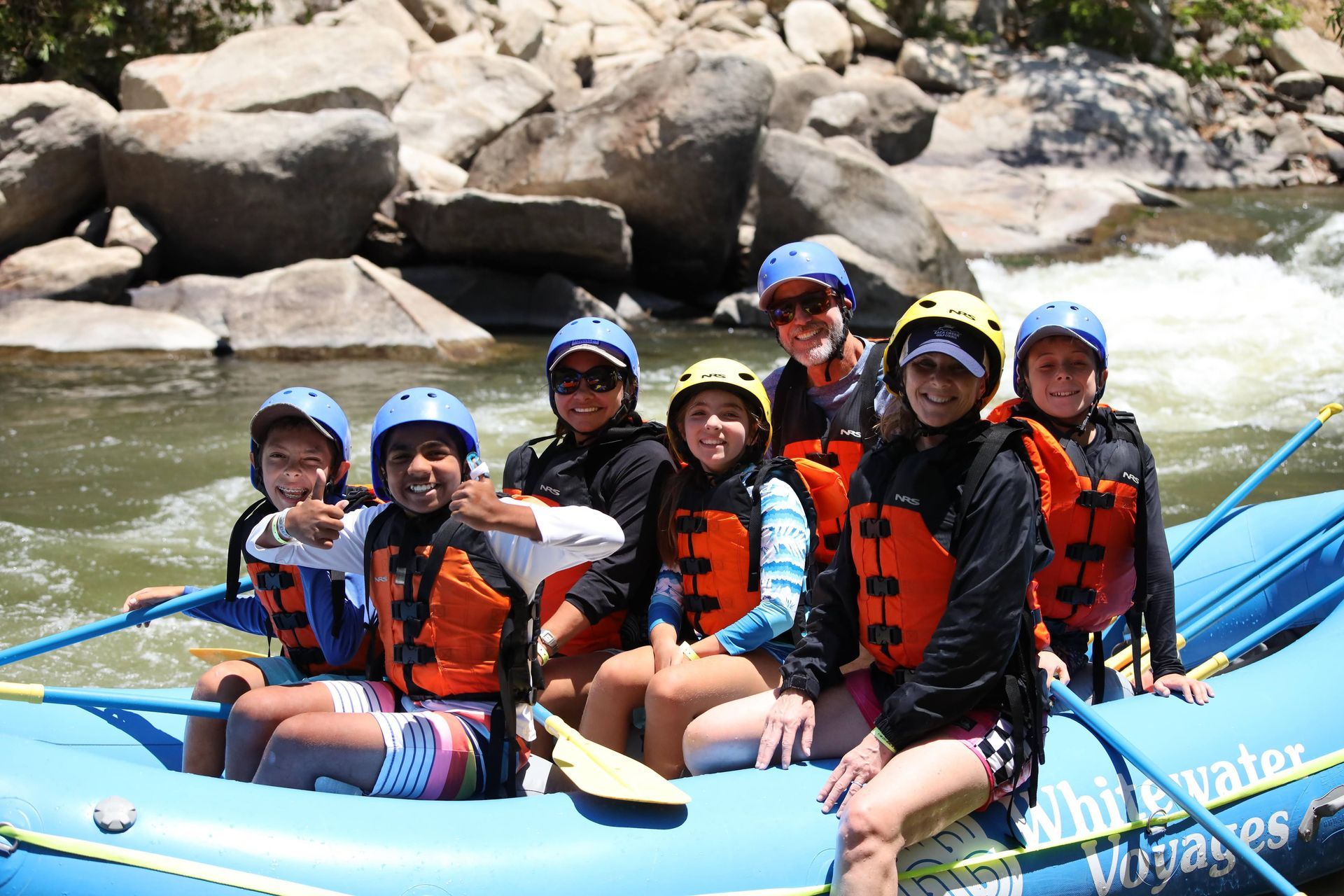 A group of people are sitting on a raft in the water.