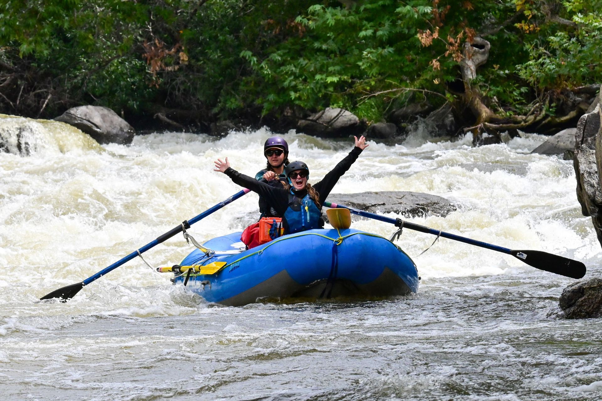 two females in a raft going down rapids 