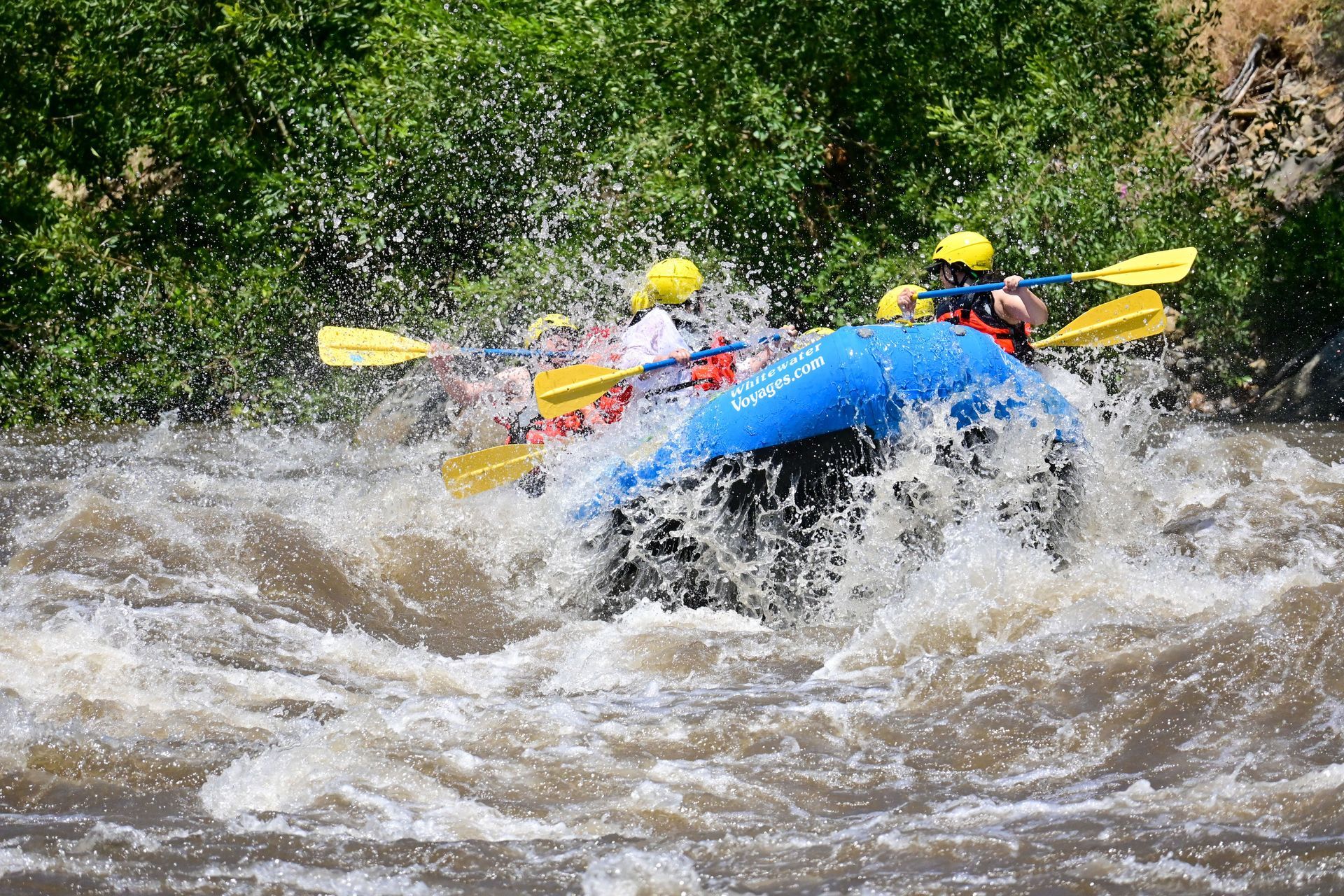 people in a blue raft in whitewater