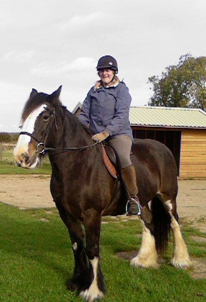 Lorraine on Dolly with firm grip on reins and back protector worn for safety.