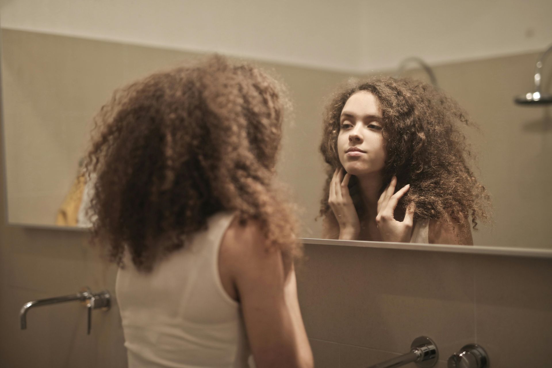 A girl looking at herself in a mirror.