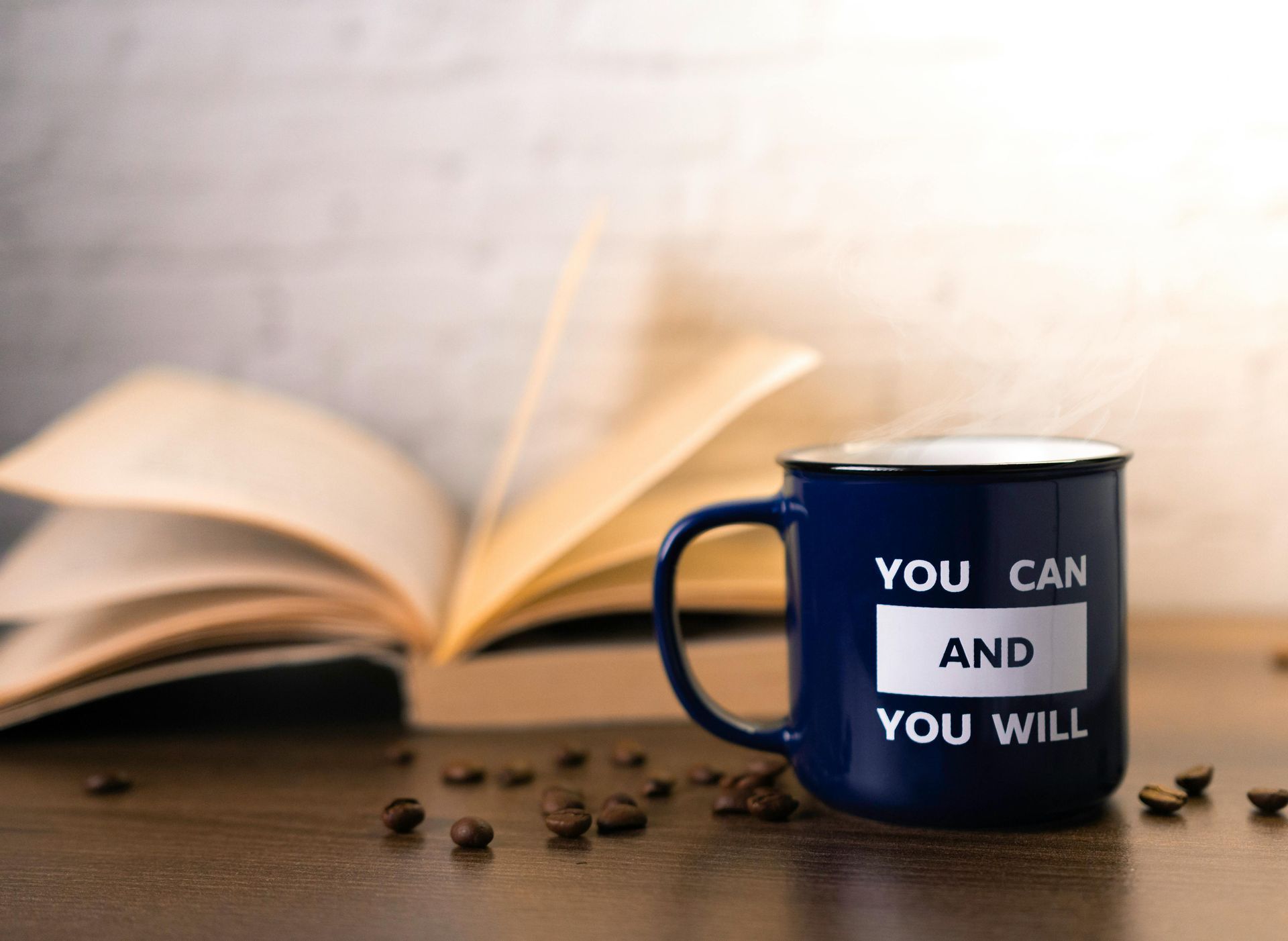 An open book with a printed mug saying you can and you will