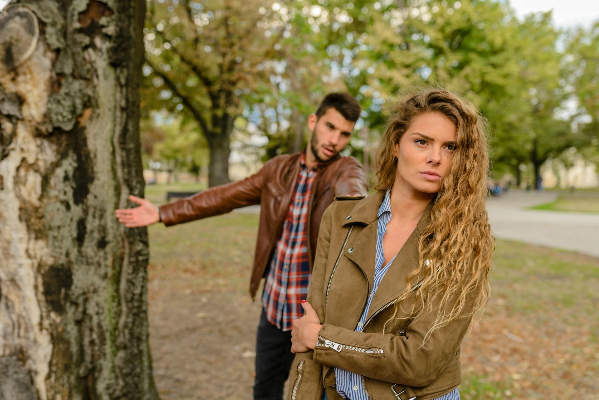 A woman looking angry with her back to a man that looks as though he is pleading with her.
