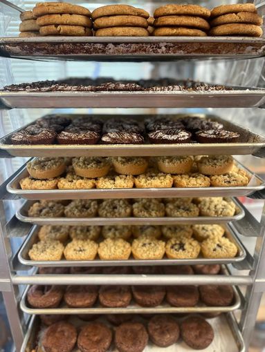 Shelves stacked with various cookies and baked goods in a bakery.