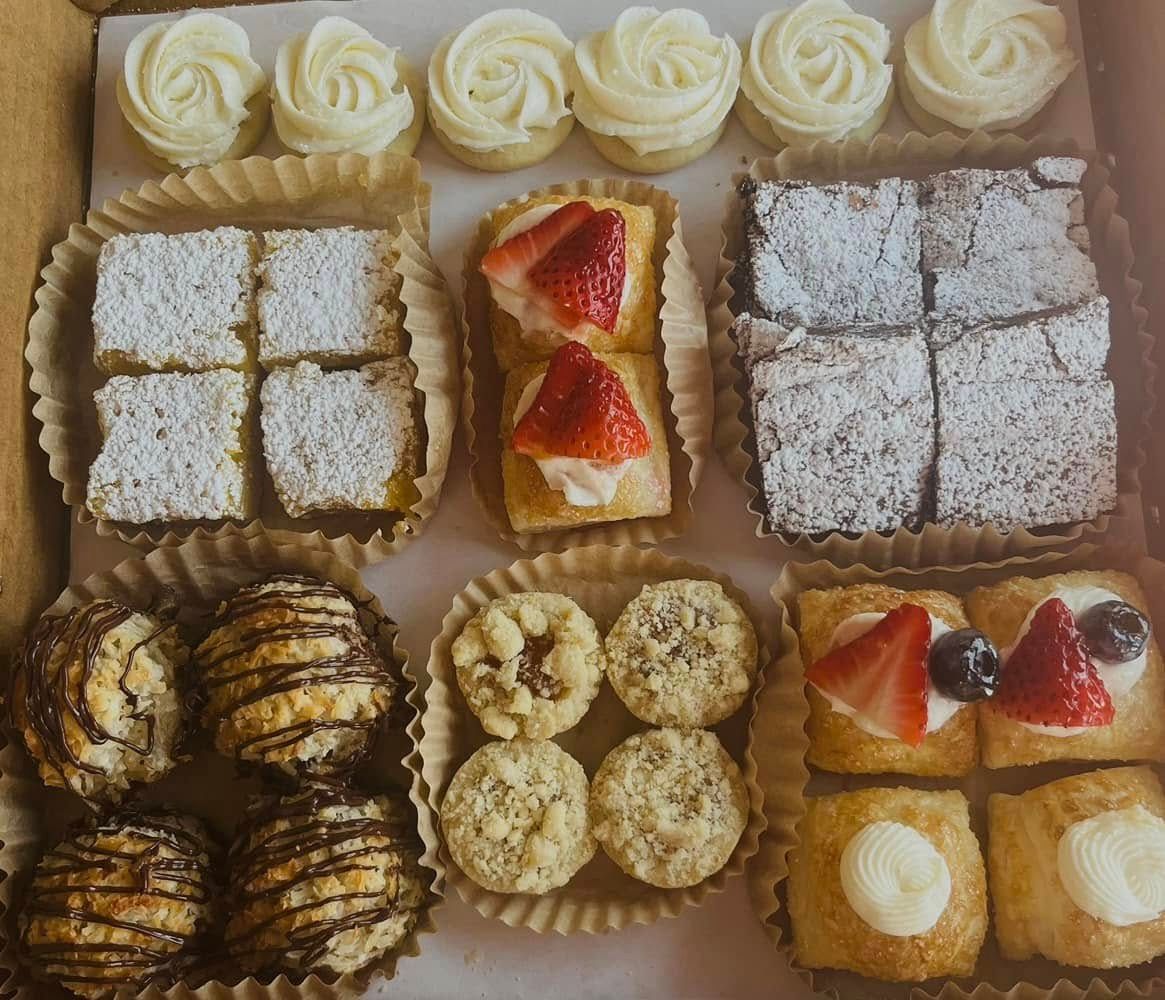 Box of assorted pastries, including cookies, brownies, and mini tarts.