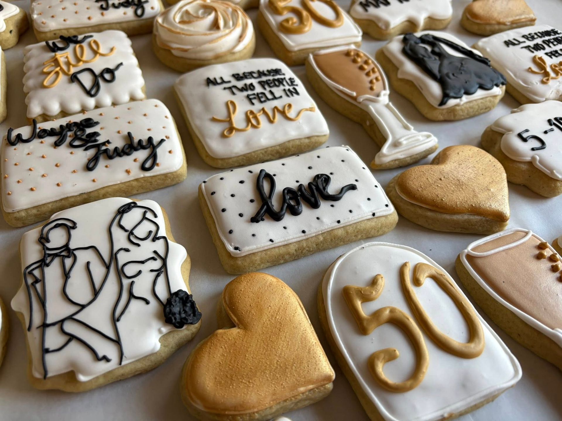 Decorated cookies with gold and black icing celebrating a 50th wedding anniversary.