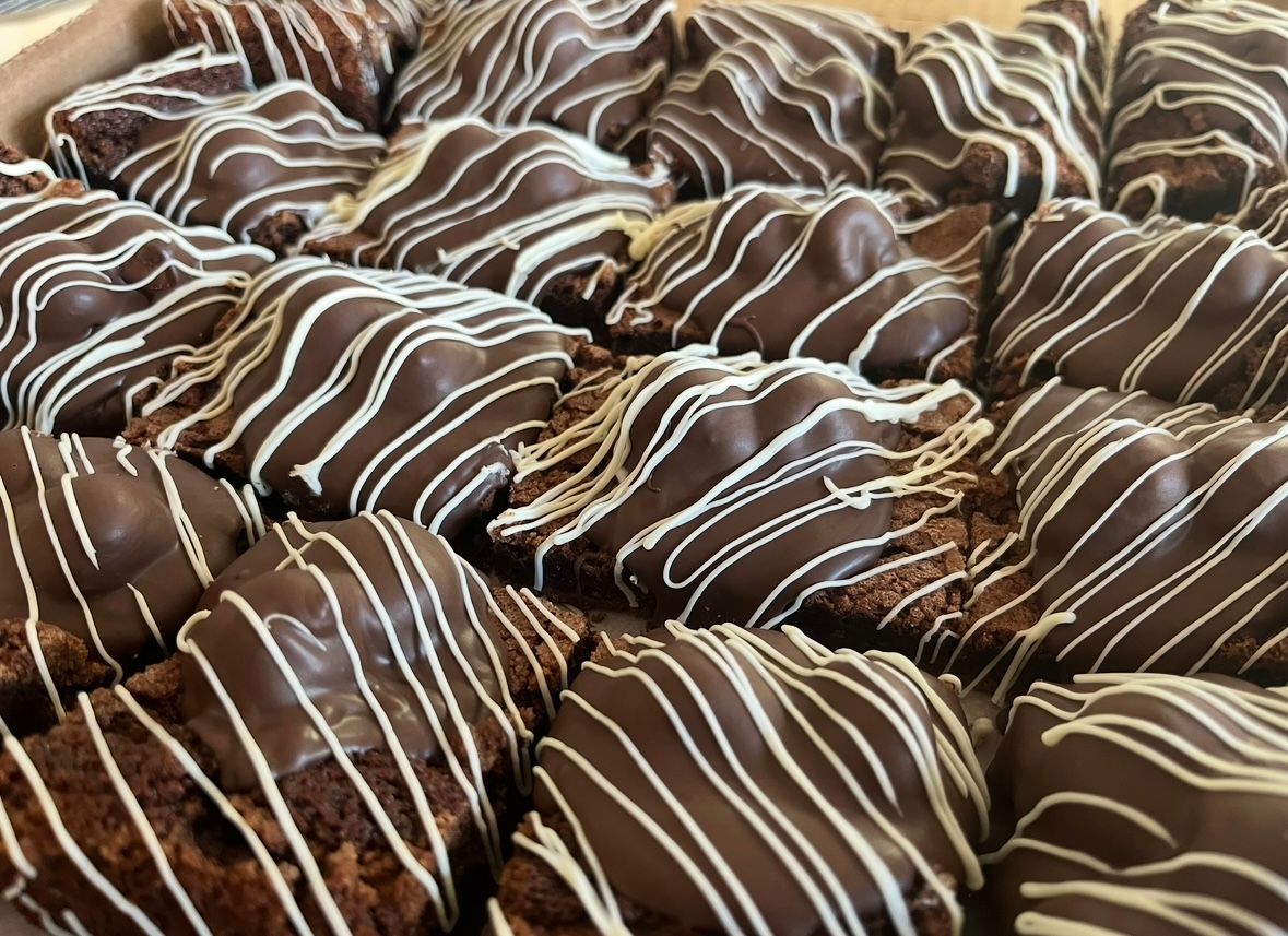 Brownies with chocolate frosting and white drizzle.