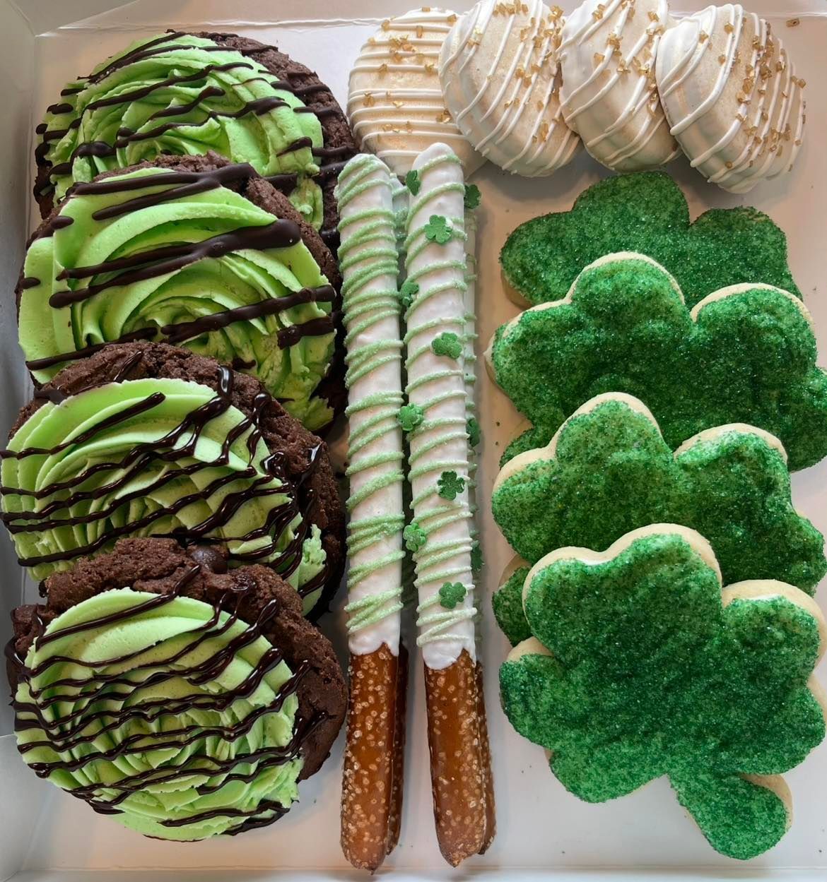 St. Patrick's Day sweets: chocolate cookies with green frosting, pretzels, shamrock cookies, and cake pops.