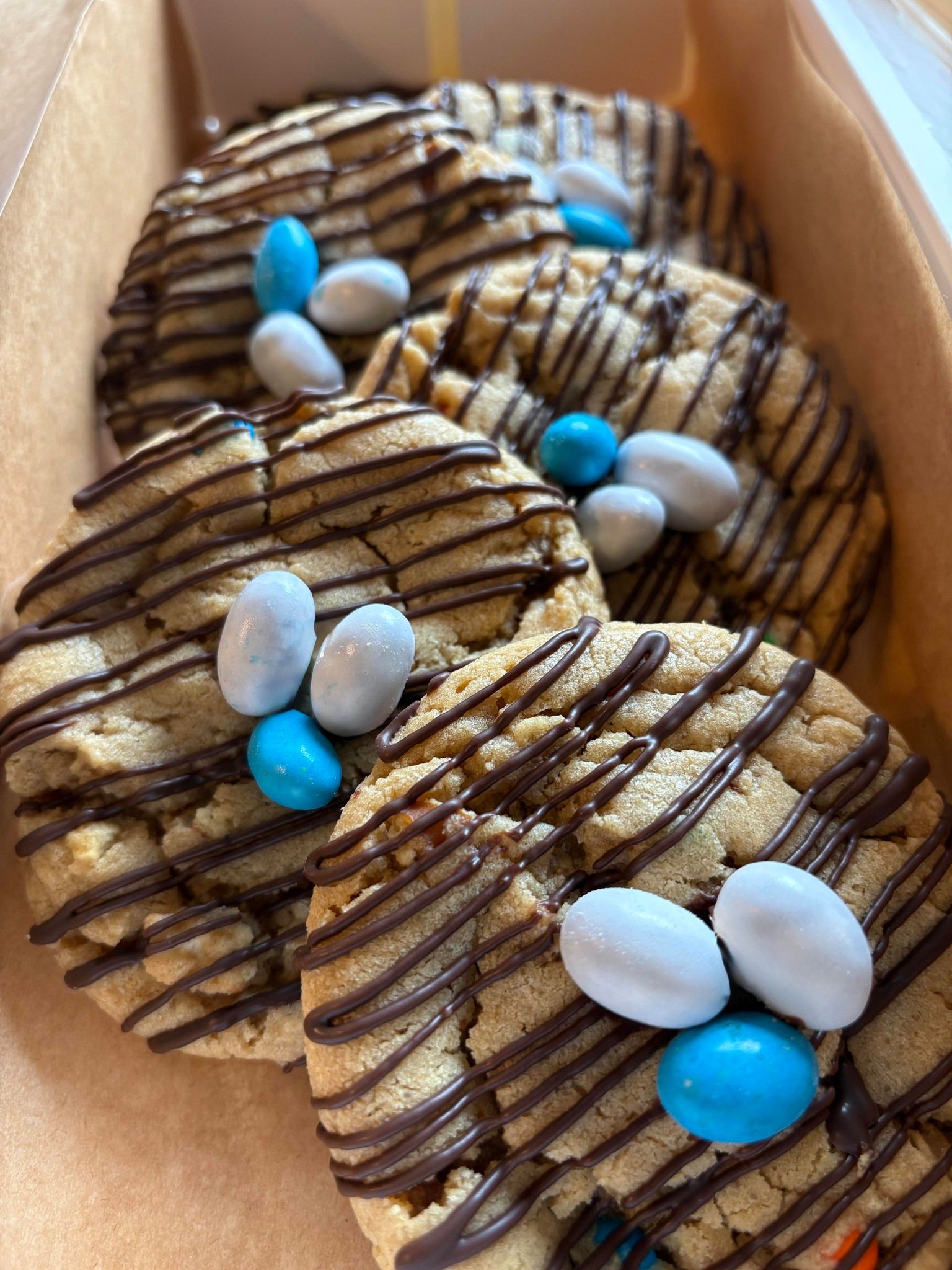 Cookies drizzled with chocolate and decorated with blue and white candy.