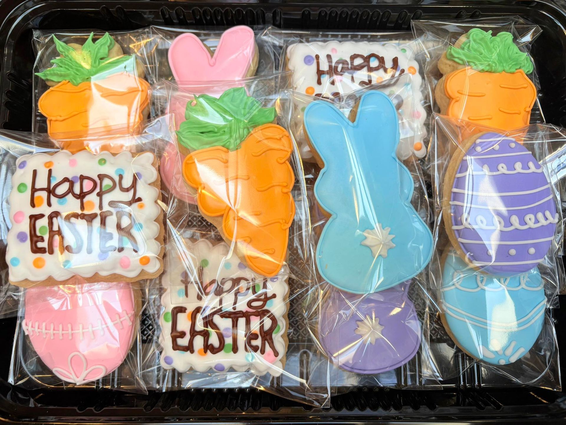 Easter cookies in a tray, decorated with carrots, bunnies, eggs, and 