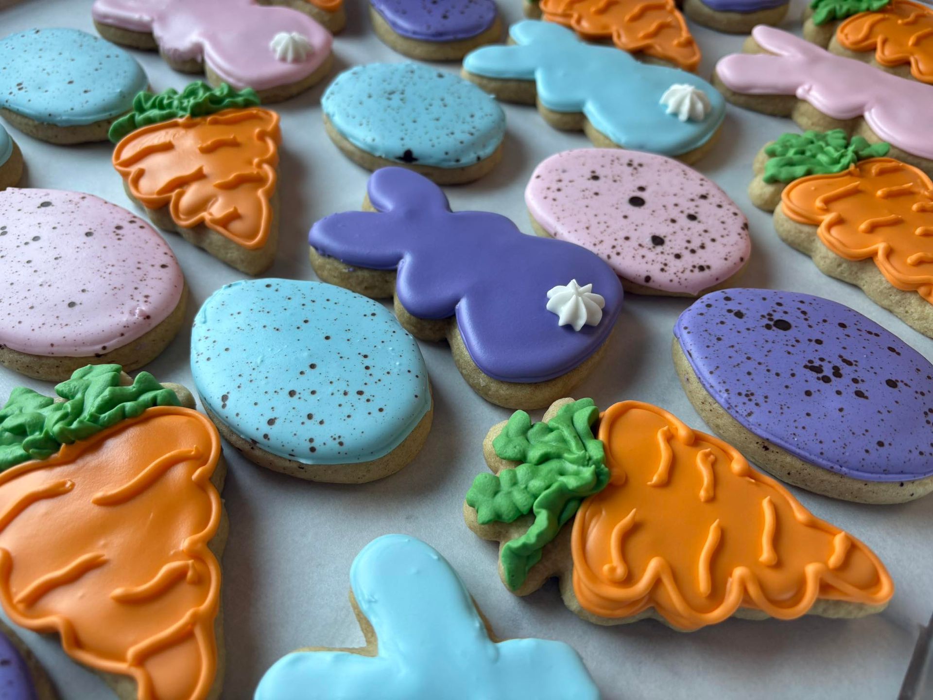 Easter cookies: carrots, bunnies, and speckled eggs, iced in pastel colors.
