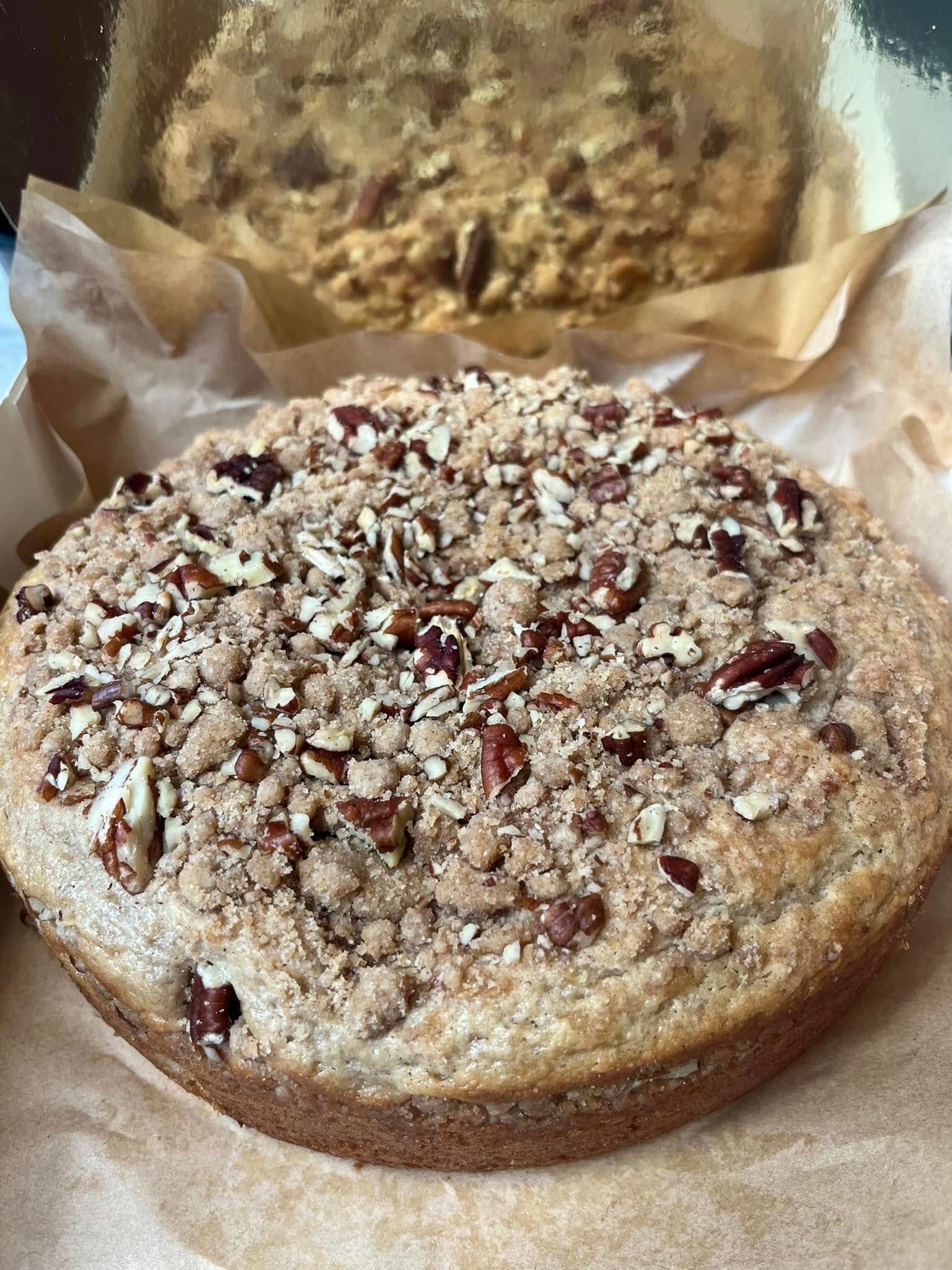 Coffee cake with pecan crumble topping on parchment paper.