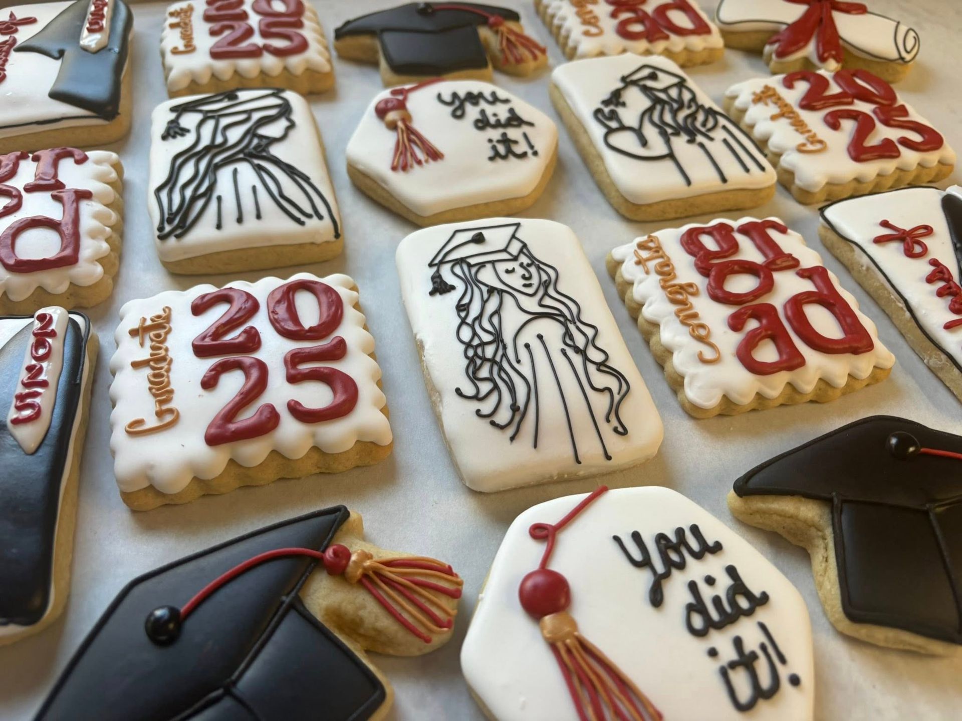 Graduation-themed decorated cookies, featuring mortarboards, gowns, 