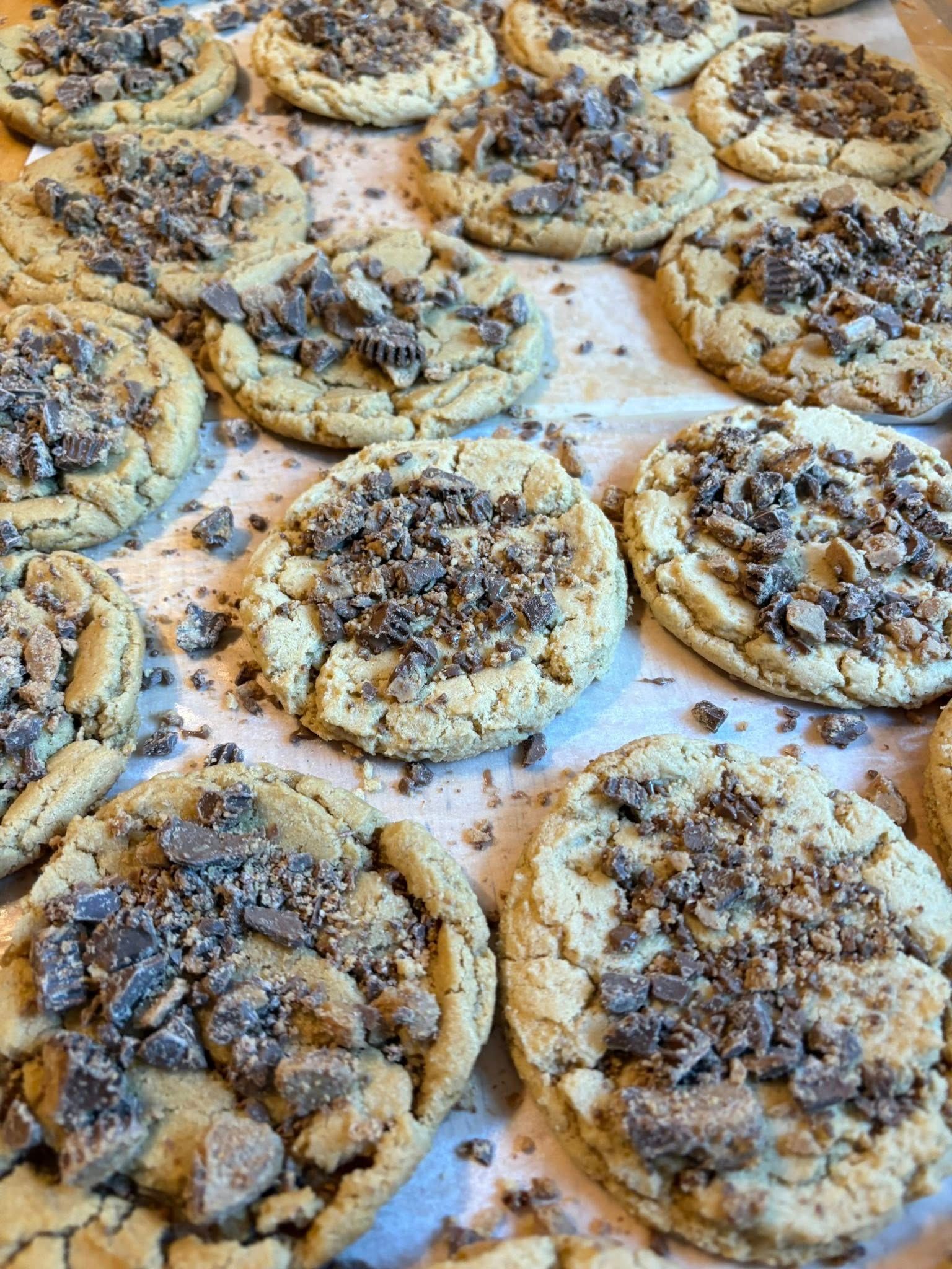 Cookies with crushed candy topping on a baking sheet.
