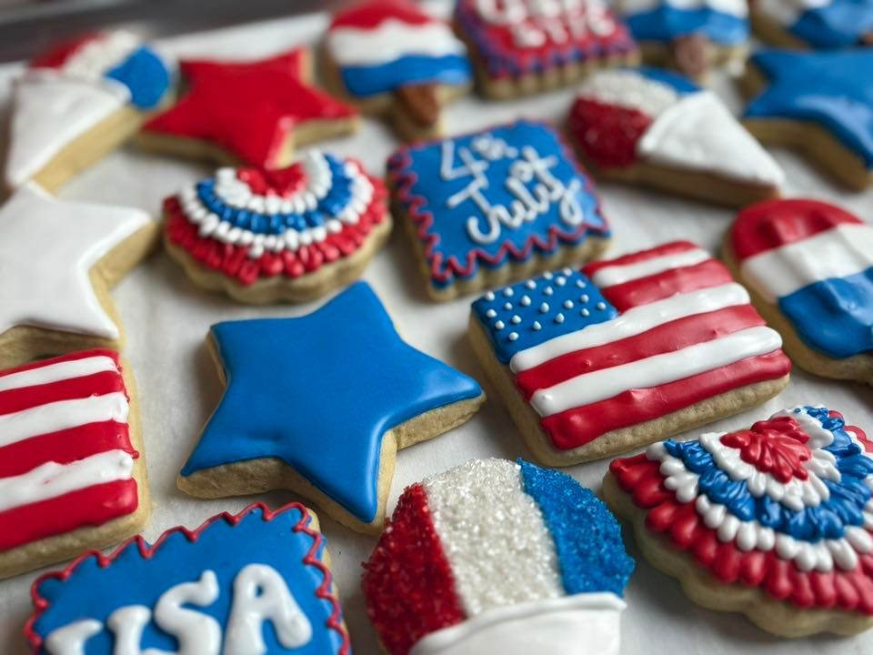 Assortment of patriotic cookies decorated with red, white, and blue icing for the 4th of July.