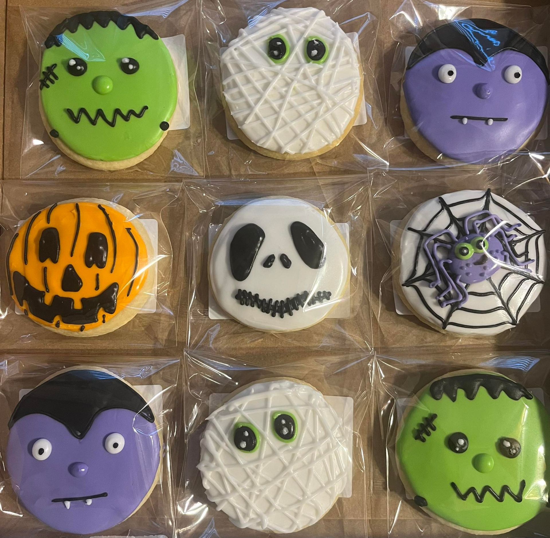 Nine Halloween-themed cookies in a box: Frankenstein, mummy, vampire, pumpkin, Jack Skellington, spiderweb, etc.