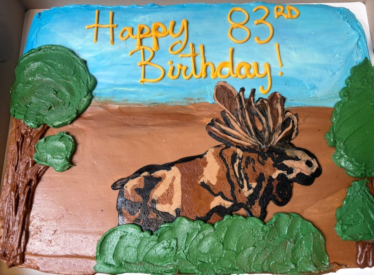 Cake decorated with a moose, trees, and 