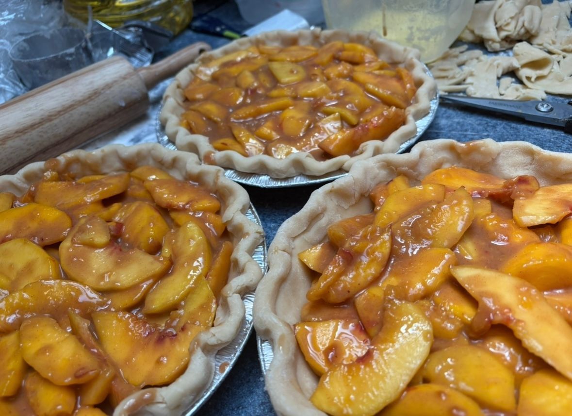 Three peach pies, golden brown, in their crusts.