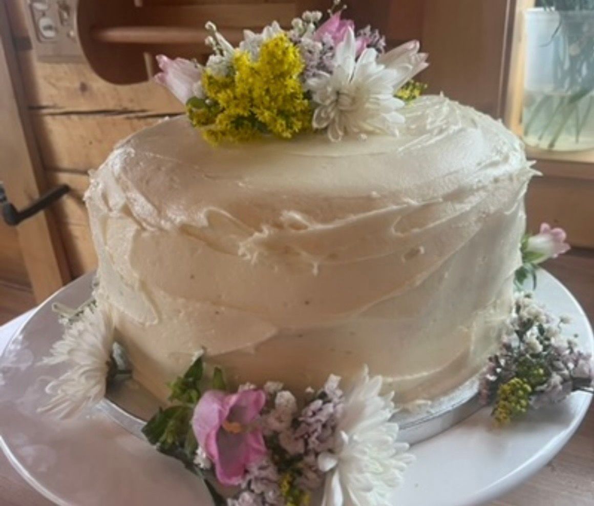 Cake with white frosting and floral decorations.