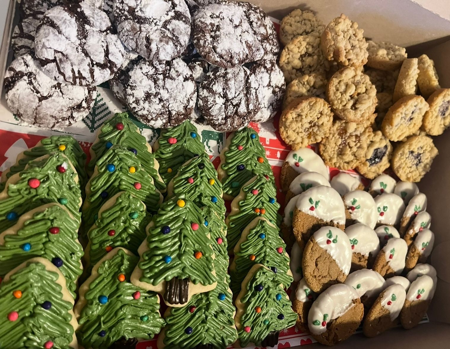 Cookies in cellophane packaging: chocolate crinkles, white-dipped with holly, and crumble-topped.