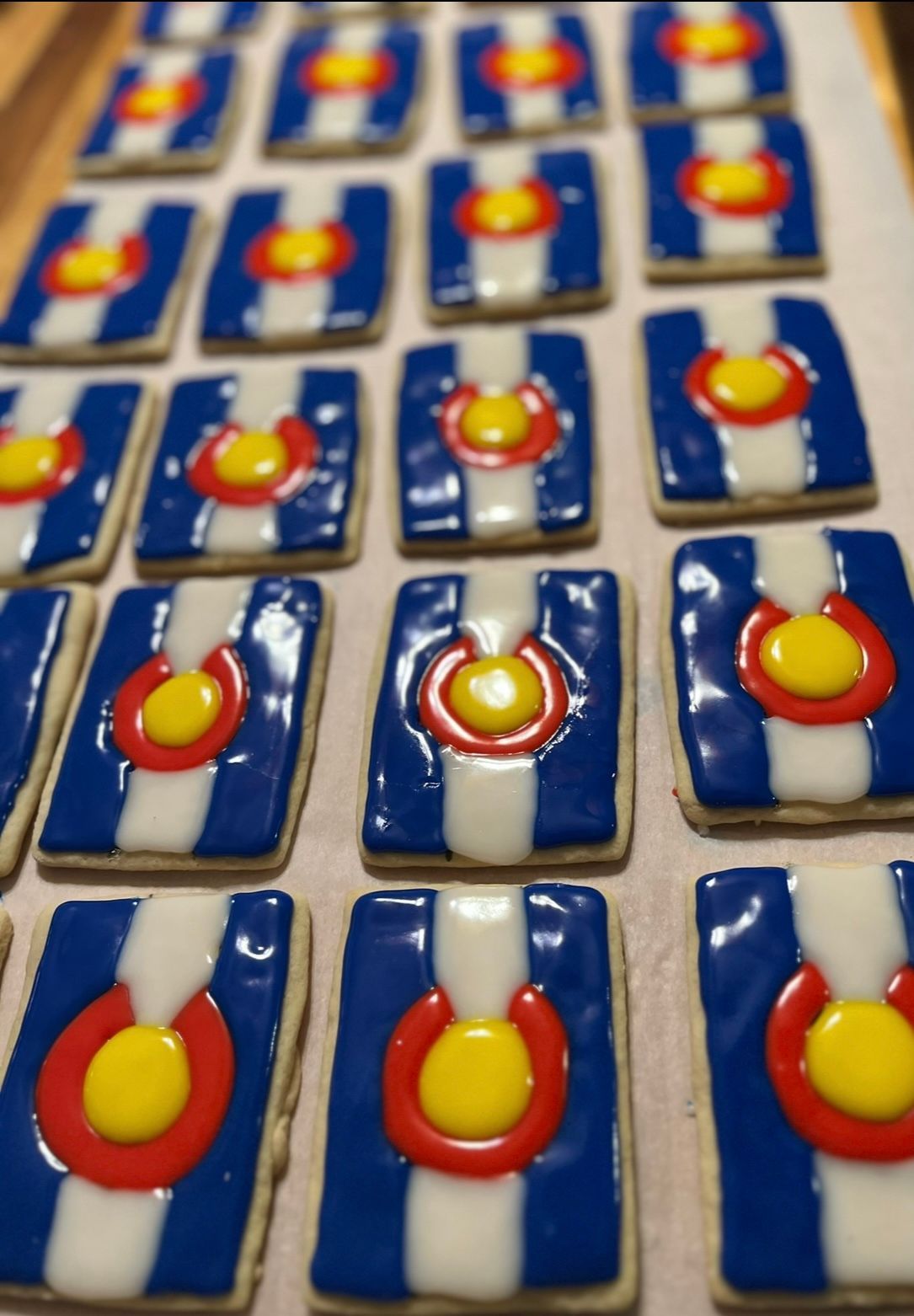 Cookies decorated with the Colorado flag: blue, white, and red stripes with a yellow center.