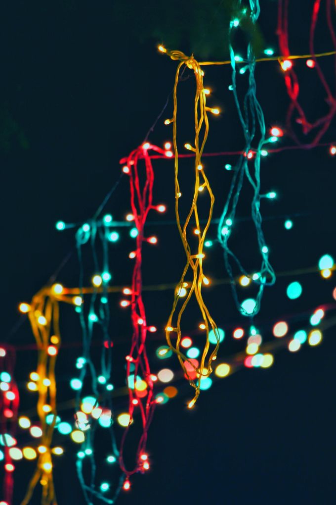 A bunch of colorful christmas lights hanging from a wire