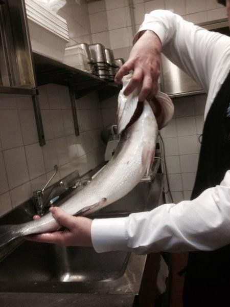cuoco mentre prepara il pesce