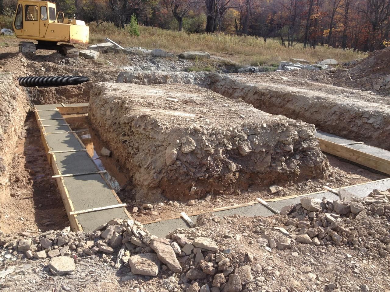 A Construction Site With a Yellow Excavator in the Background