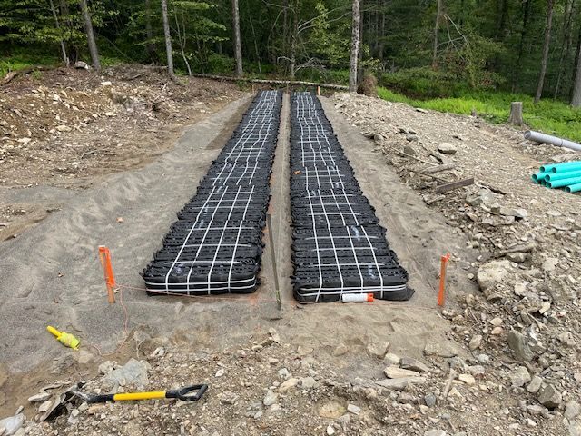 A Row of Black Bags Sitting on Top of a Dirt Road