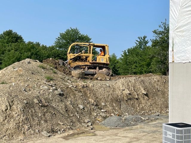 A Bulldozer is Sitting on Top of a Pile of Dirt