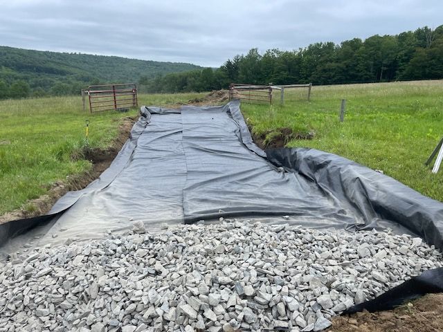Pile of Gravel is Sitting on Top of a Black Tarp in a Field
