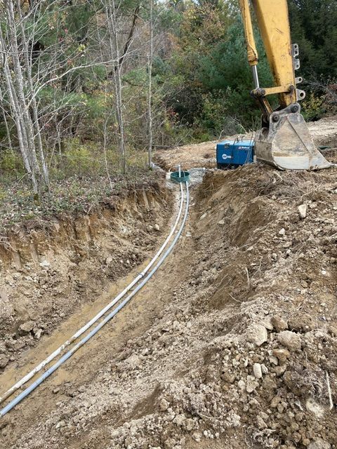 A Yellow Excavator is Digging a Trench in the Dirt
