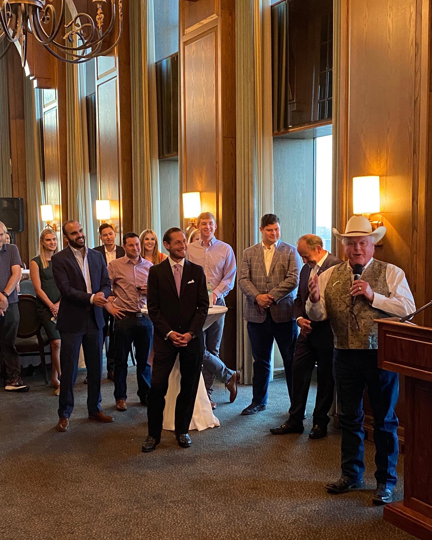 A group of people are standing around a podium in a room.