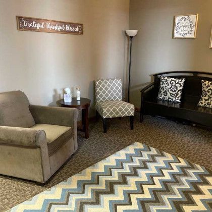 Cozy office space: armchair, chair, bench, rug. Neutral walls, inspirational signs.