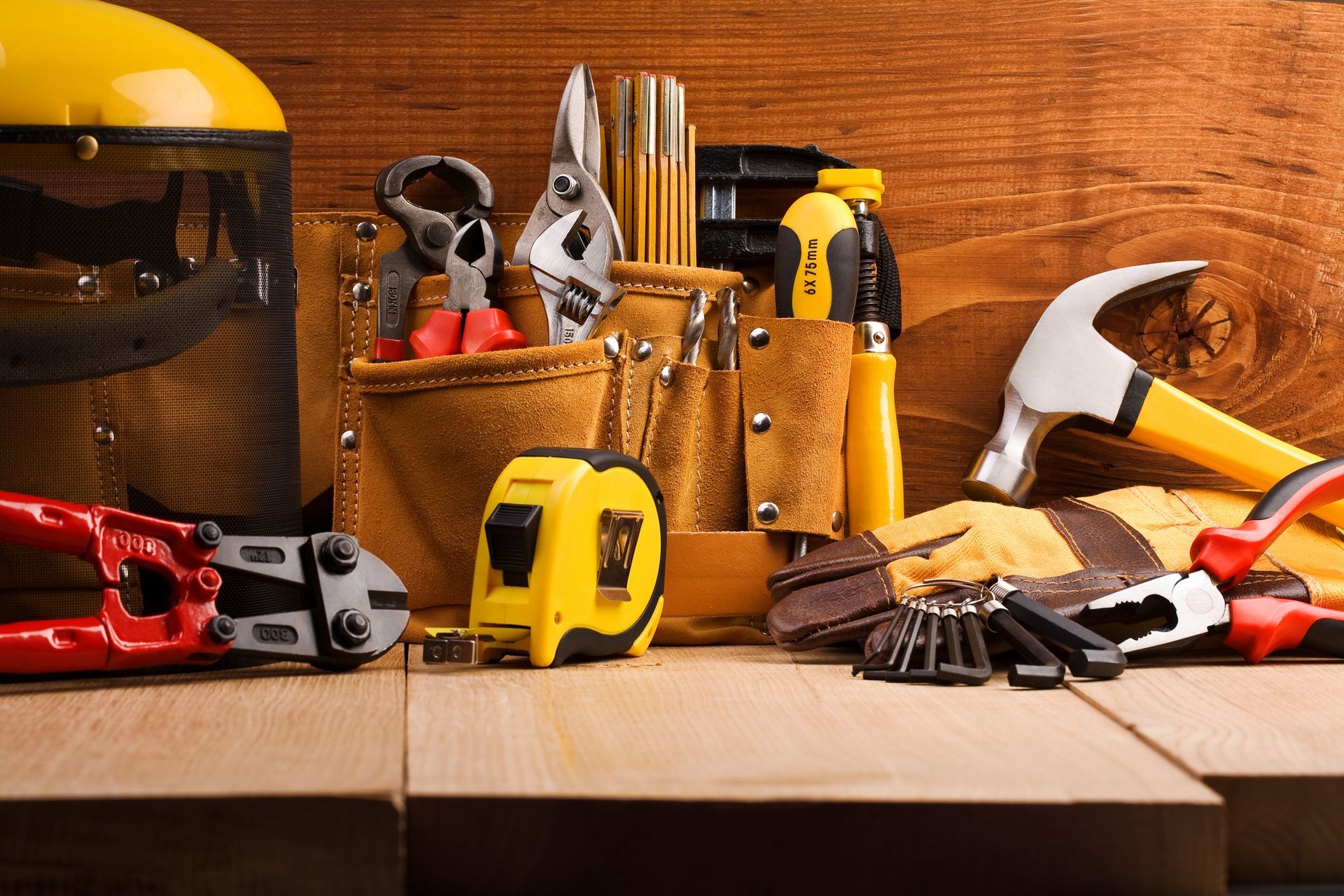 A bunch of tools are sitting on a wooden table.