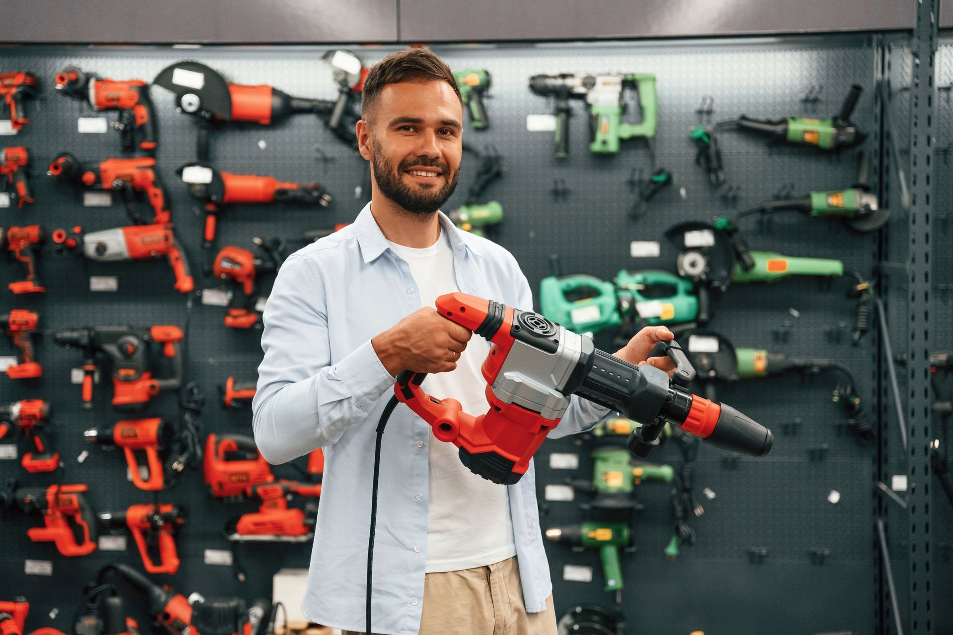 Man holding a perforator, showcasing Hilti tools in a hardware store for professional contractors.