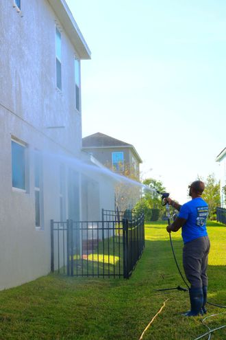 a man in a blue shirt is using a high pressure washer