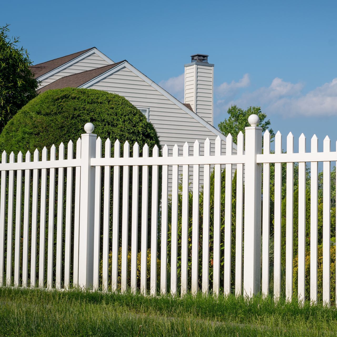 a white picket fence is in front of a house