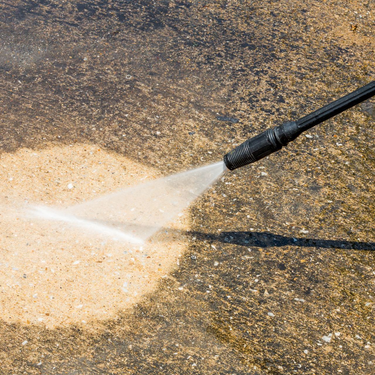 a person is using a high pressure washer to clean a concrete surface