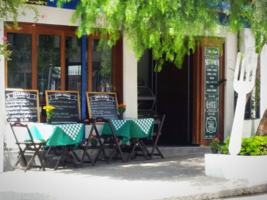 Um restaurante com mesas e cadeiras na frente