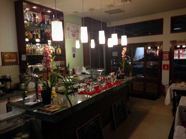 Um bar em um restaurante com flores no balcão