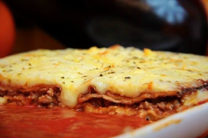 Um close de uma caçarola com carne e queijo por cima.