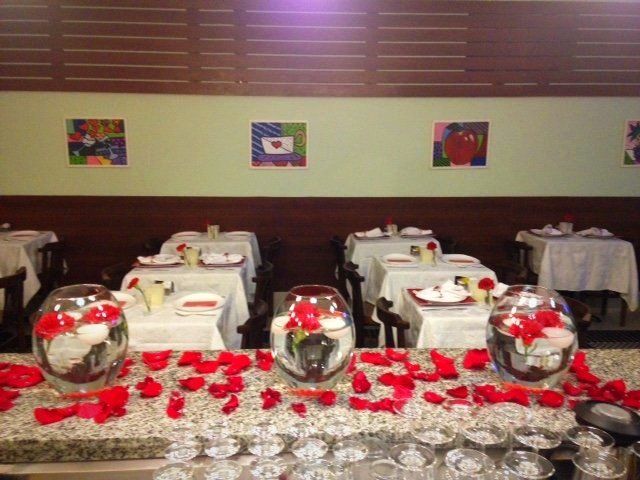 Uma sala de jantar com mesas e vasos cheios de flores