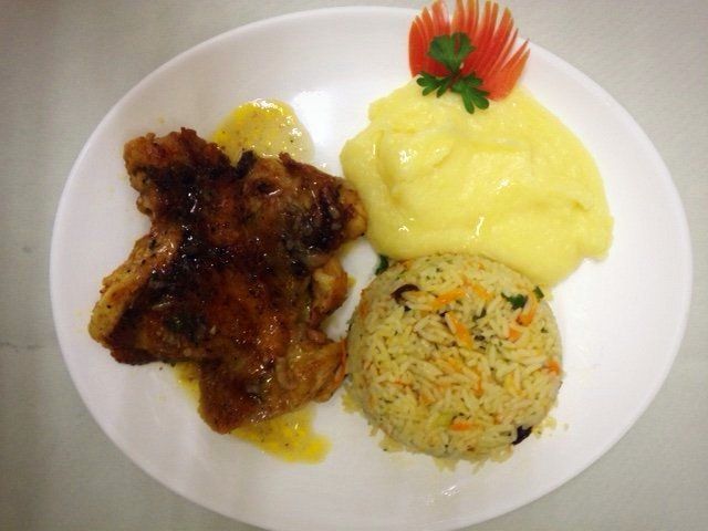 Um prato de comida com purê de batata e arroz