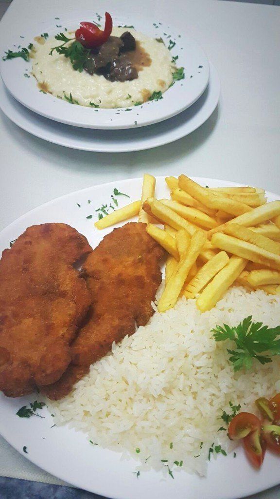 Um prato de comida com arroz e batatas fritas sobre uma mesa.