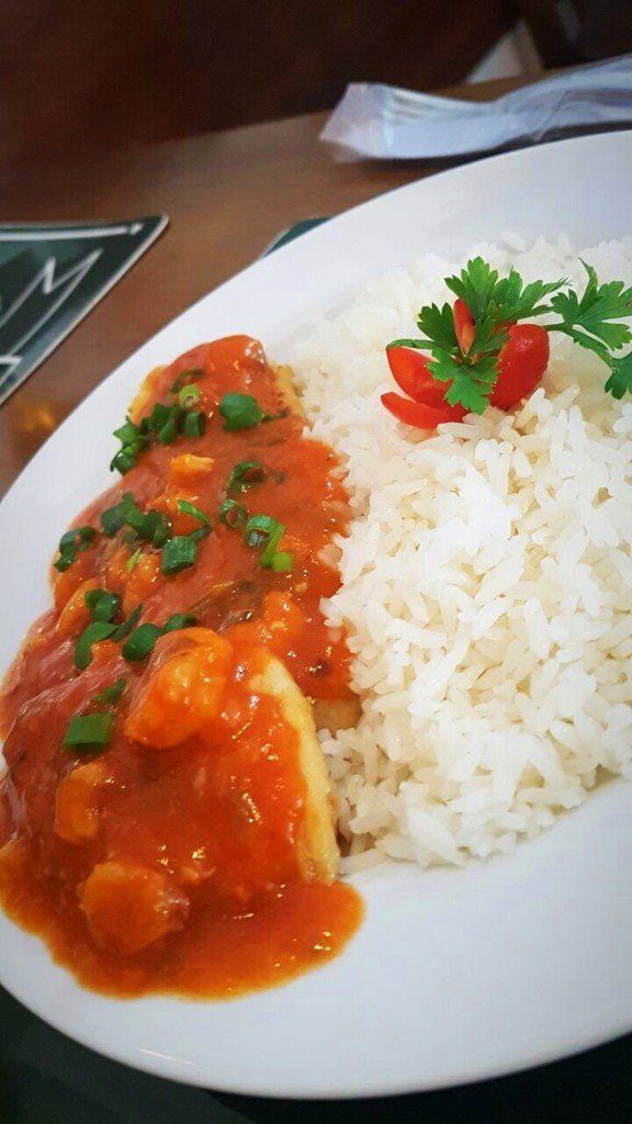 Um prato de comida com arroz e molho sobre uma mesa