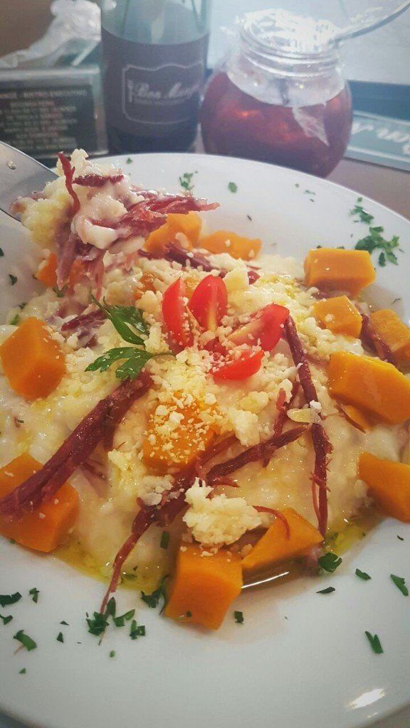 Um close de um prato de comida com tomates e cenouras em uma mesa.