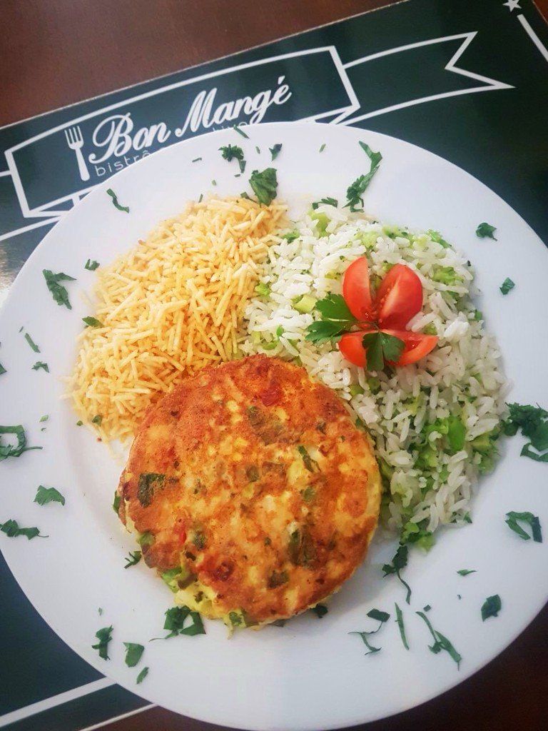 Um prato de comida sobre uma mesa com uma placa que diz sarna boa