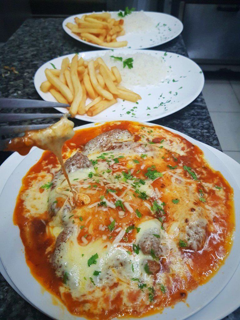 Um prato de comida com batatas fritas ao lado