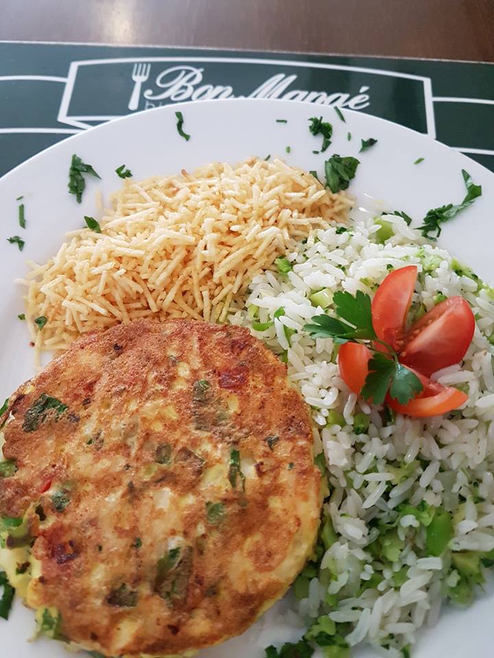 Um prato de comida com arroz e tomate